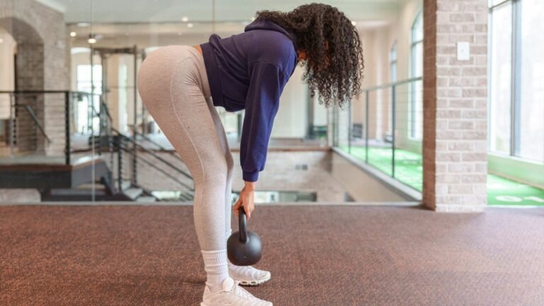 Woman performs Romanian deadlift using a kettlebell