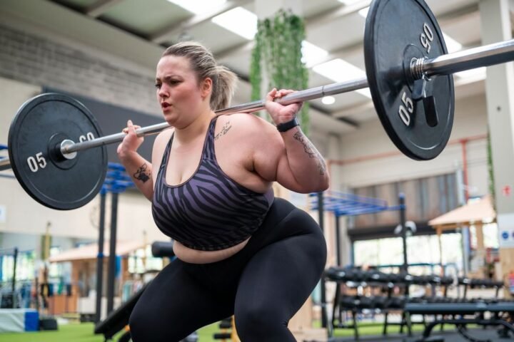 Woman performing a barbell squat at a gym