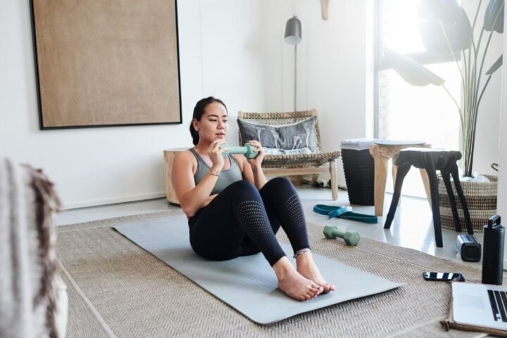 Woman performs weighted sit-up