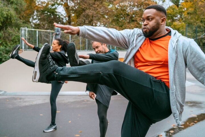 Man performing high kicks in an outdoor exercise class