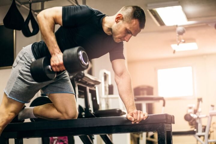 Man doing a dumbbell arm workout at the gym