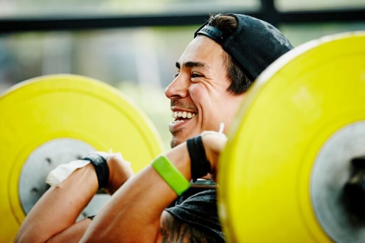 Man holding barbell across his chest in front rack position