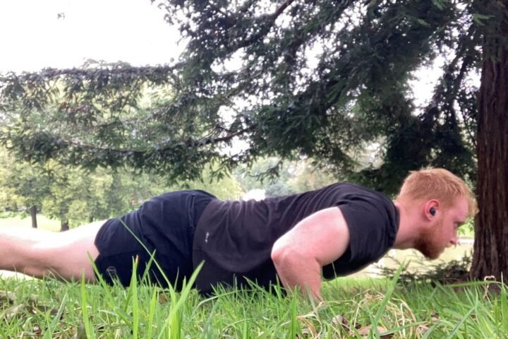 The author performs a push-up on grass