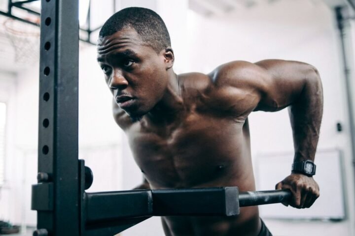 Man performs triceps dips in gym