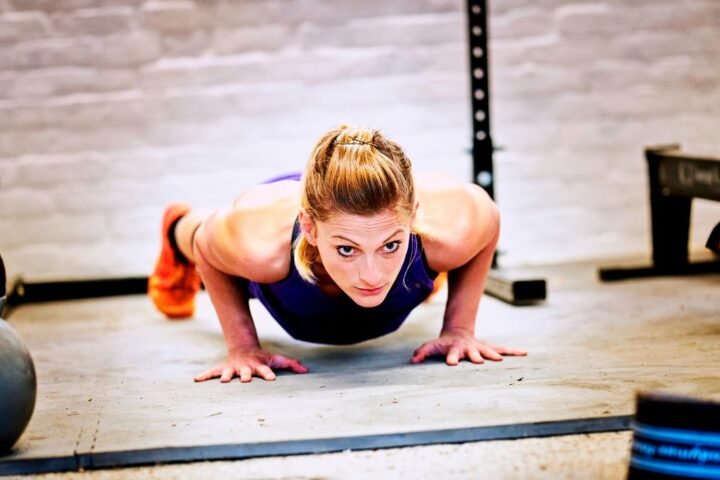 Woman performs push-up in a garage