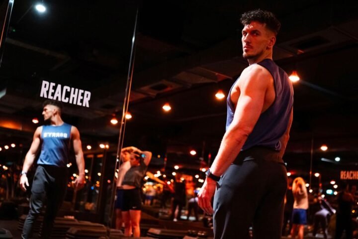 Barry&rsquo;s Bootcamp trainer facing floor-to-ceiling mirror. The word Reacher is printed on the mirror