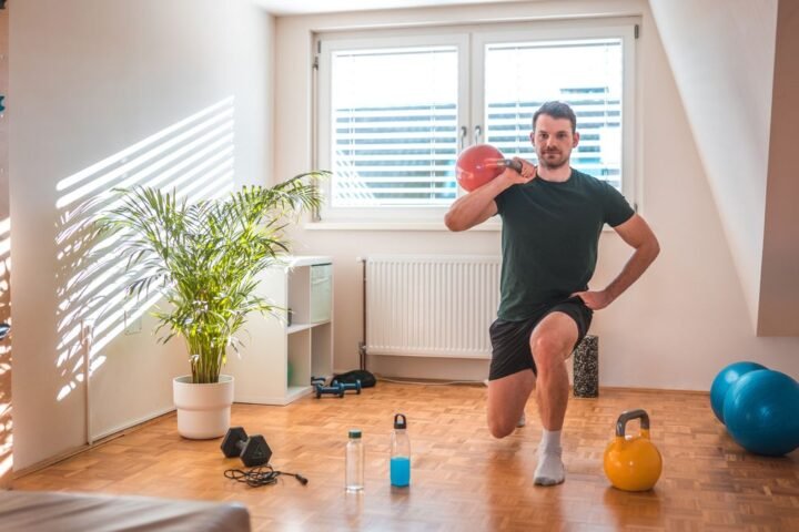 Man works out with kettlebell at home