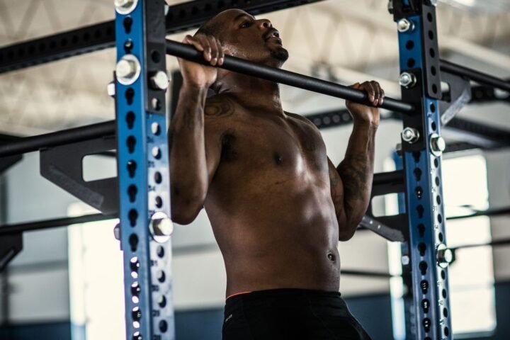 Man performing pull-up in gym