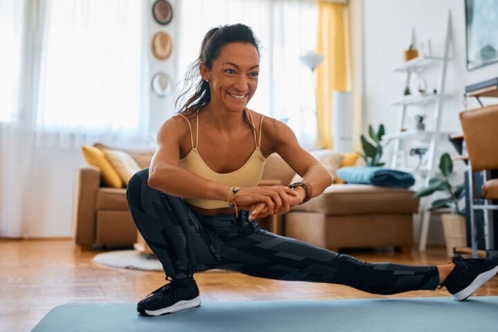 Woman performing Cossack squat at home