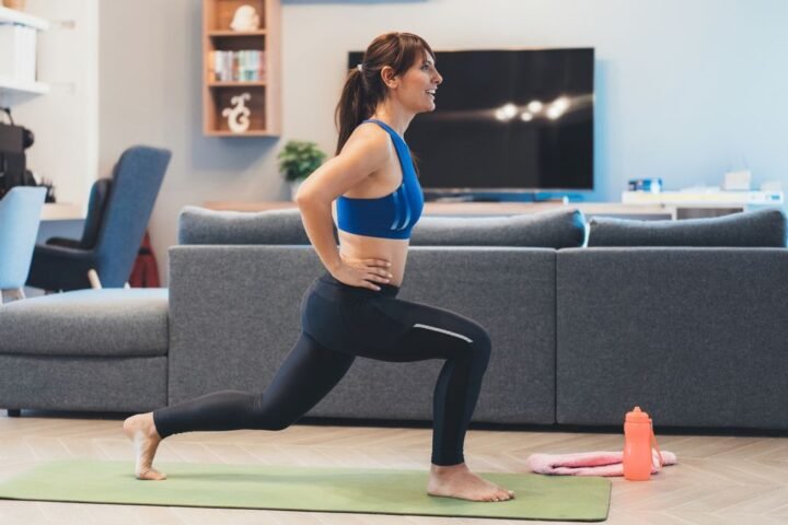 Woman performing lunge exercise in living room