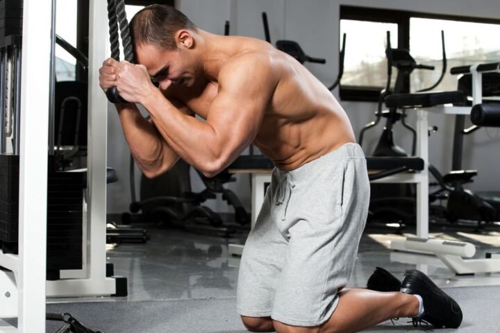 Man performing cable crunch in gym