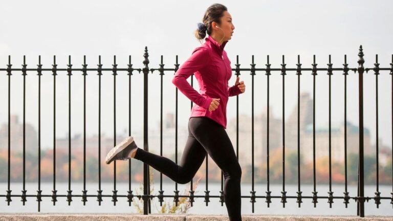 Woman running next to fence