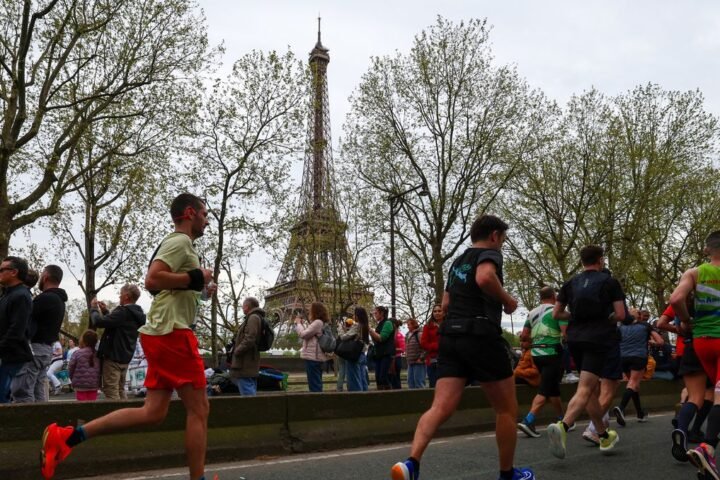 Participants run near the Eiffel Tower during the Paris Marathon 2024