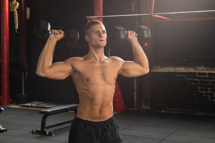 Man holding dumbbells by his shoulders