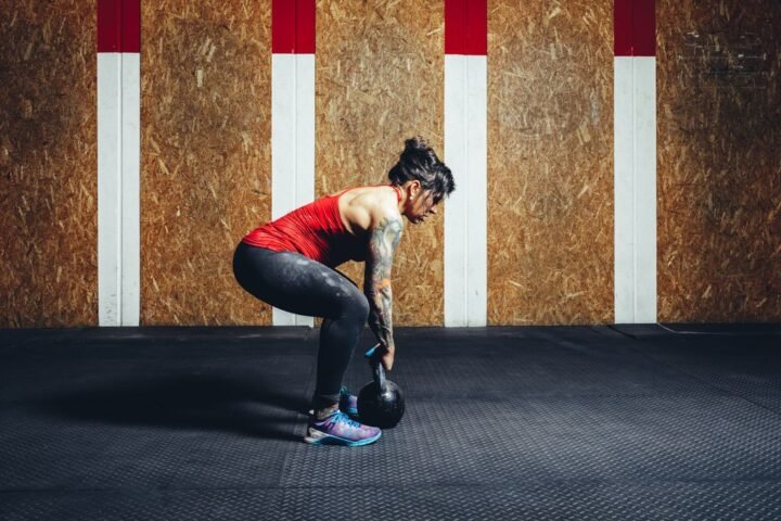 Woman performing deadlift with kettlebell